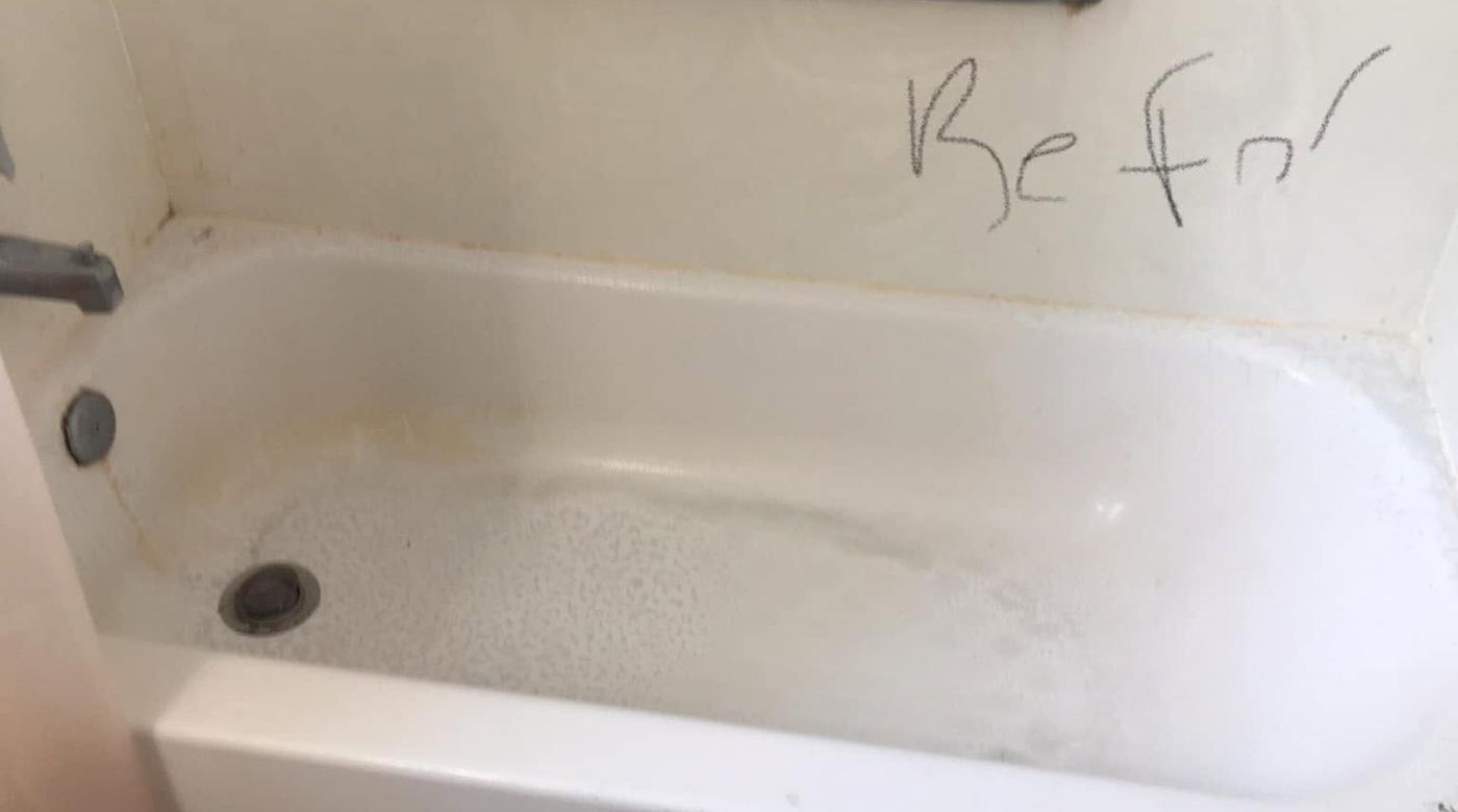 Tub with a grab bar, before we cleaned it
