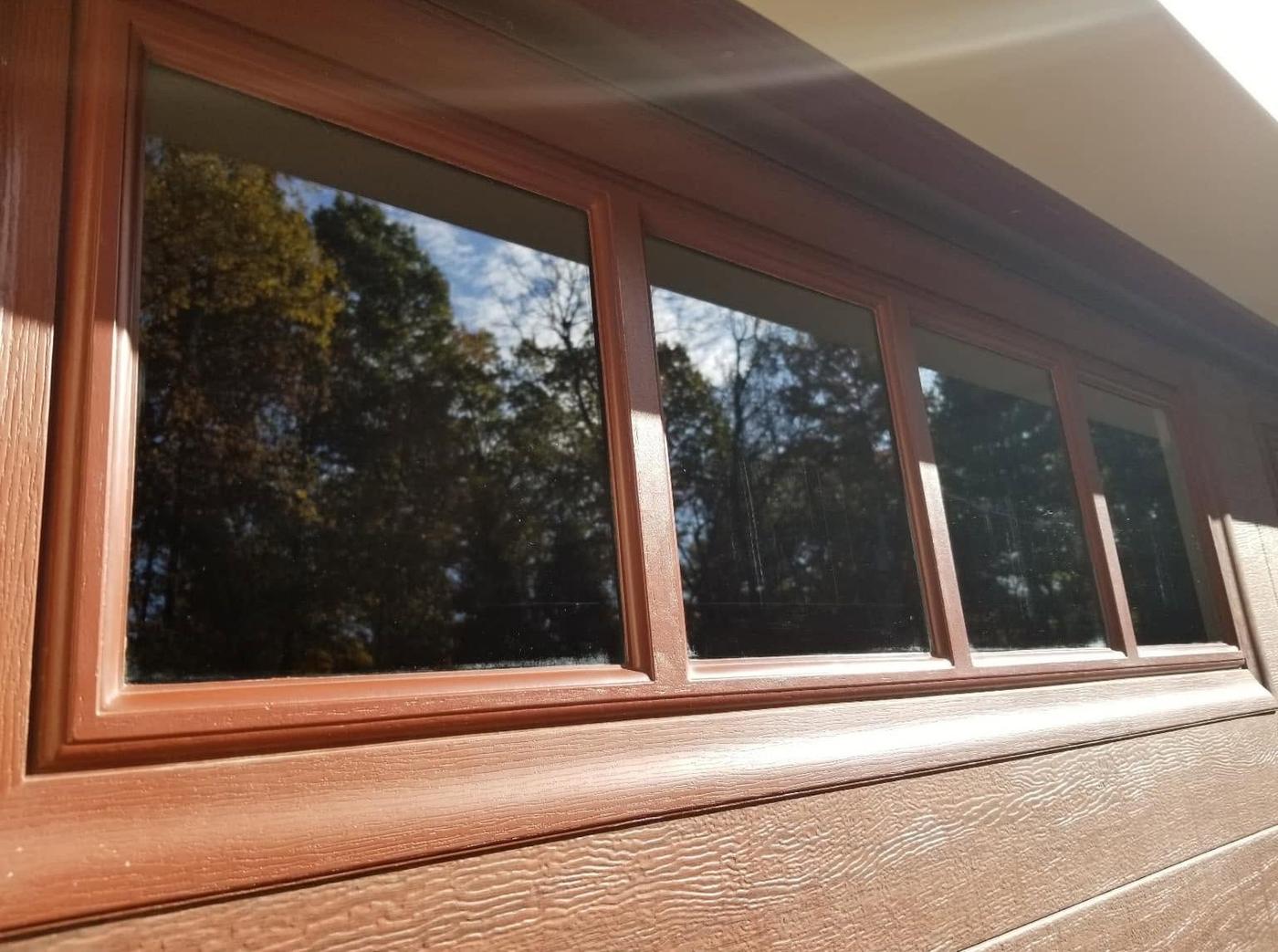 A row of wood-framed windows seen from below, from outside