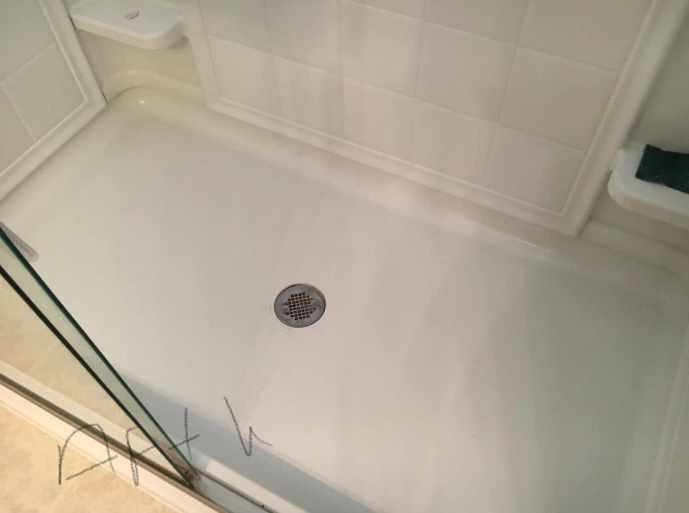 Shower floor behind a glass door, after we cleaned it